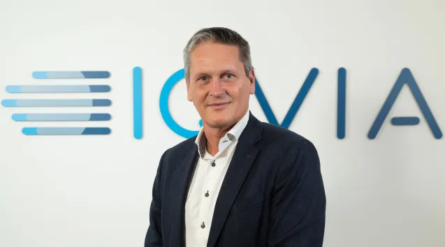 Foto av Stefan Ohlsson framför logotyp